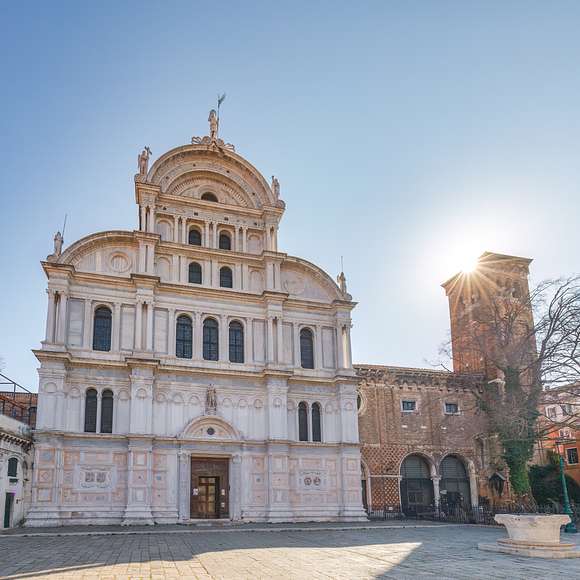 Morning sun peeks behind Venice’s Church of San Zaccaria, lighting its Renaissance façade and quiet square.