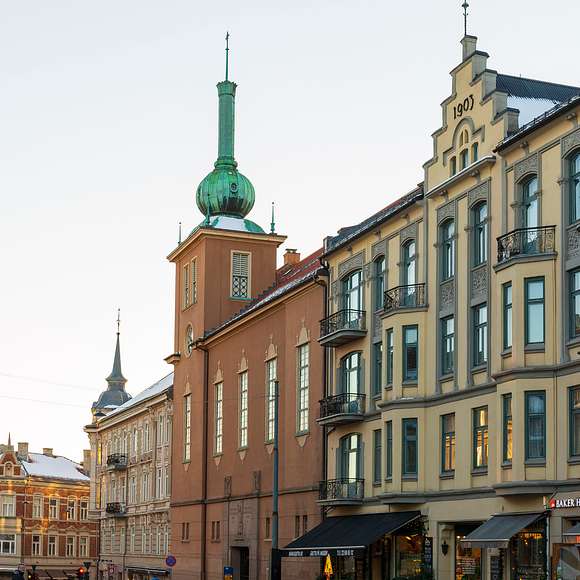 Historic buildings with ornate facades and green copper spires in central Oslo.