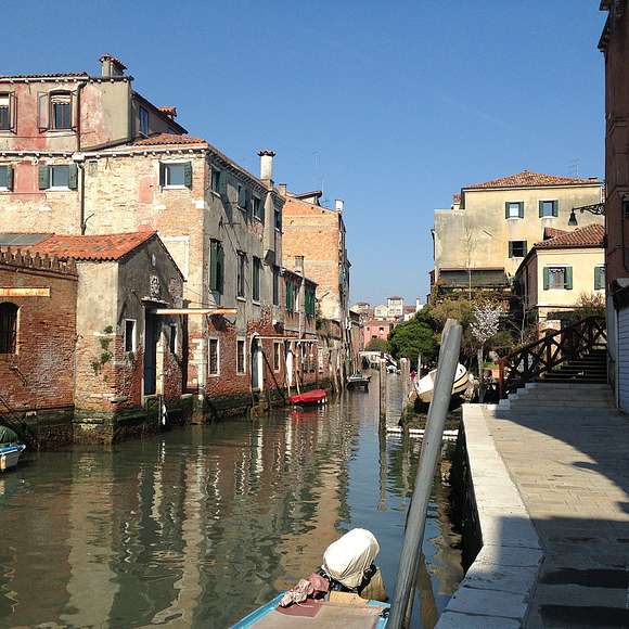 A peaceful residential canal winds through Cannaregio’s brick and pastel buildings.
